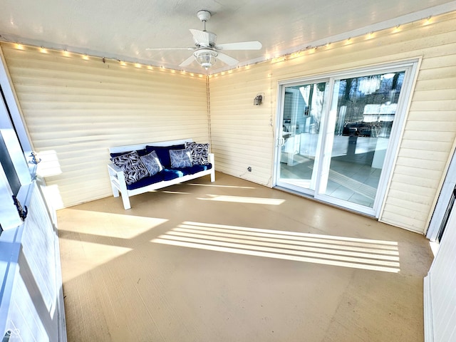 unfurnished sunroom with ceiling fan