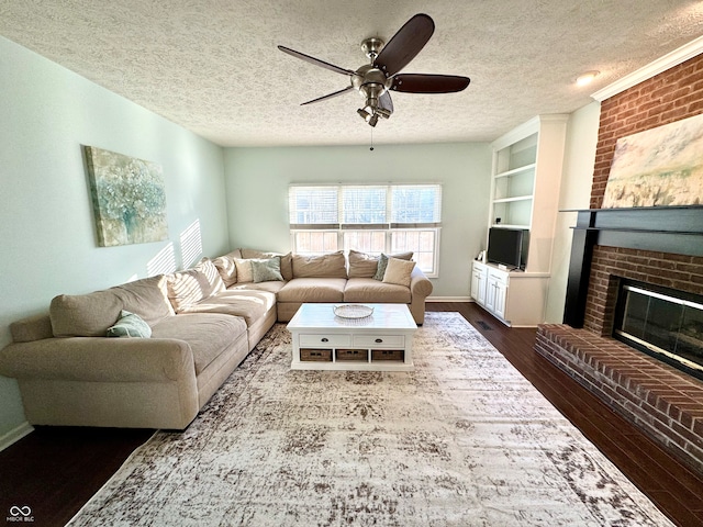 living area featuring a textured ceiling, ceiling fan, dark wood-style flooring, a fireplace, and built in features