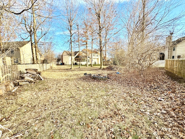 view of yard featuring fence and a fire pit