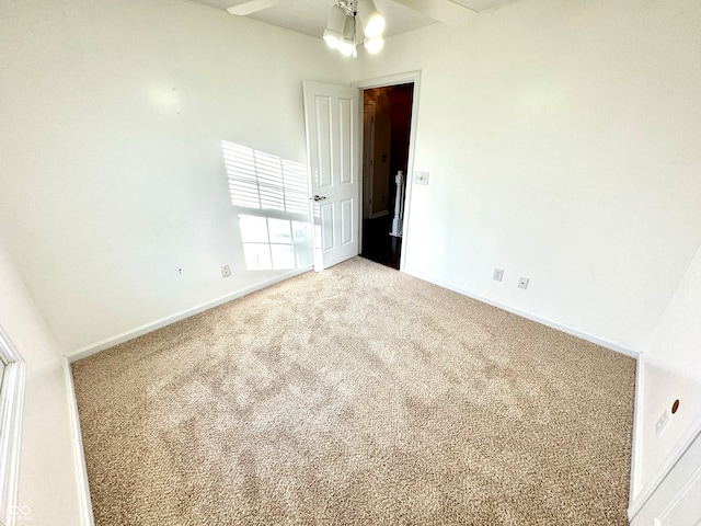 spare room featuring carpet flooring and baseboards