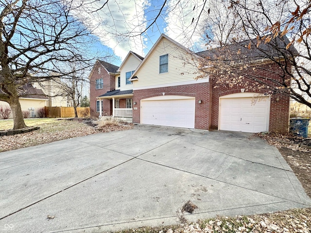 traditional-style home with brick siding, fence, driveway, and an attached garage