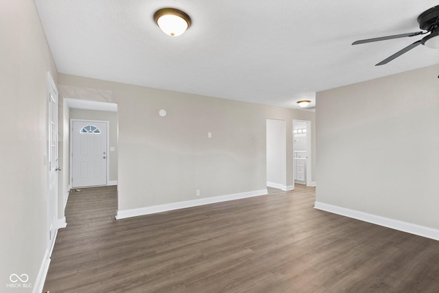 unfurnished room with a ceiling fan, dark wood-style flooring, a textured ceiling, and baseboards