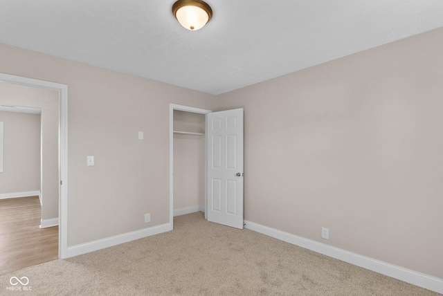 unfurnished bedroom featuring baseboards, a closet, and carpet flooring