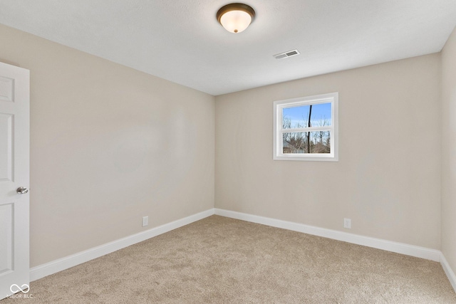 empty room featuring carpet flooring, visible vents, and baseboards