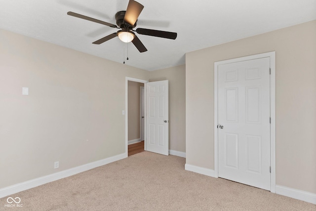 unfurnished bedroom with light carpet, ceiling fan, and baseboards