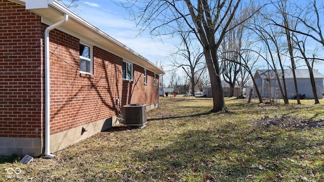 view of property exterior featuring brick siding, crawl space, cooling unit, and a lawn