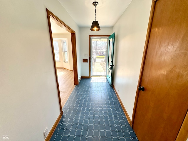 doorway featuring dark floors and baseboards