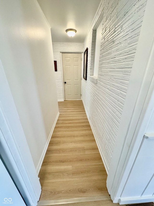 hall with baseboards and light wood finished floors