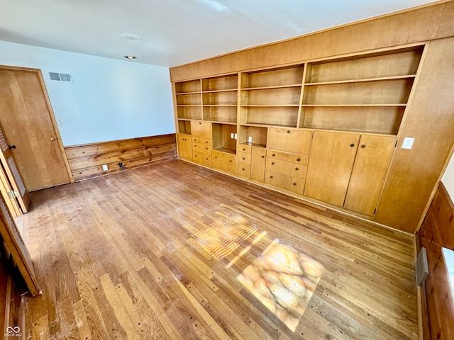 interior space with built in shelves, visible vents, and light wood-style flooring