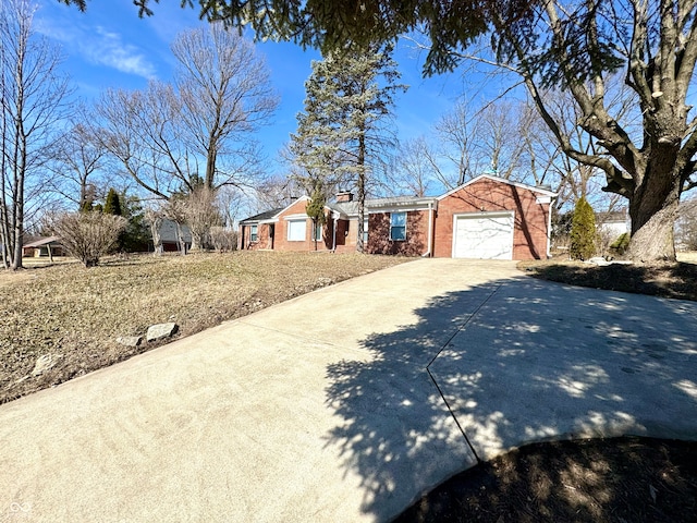 single story home with a garage, concrete driveway, and brick siding