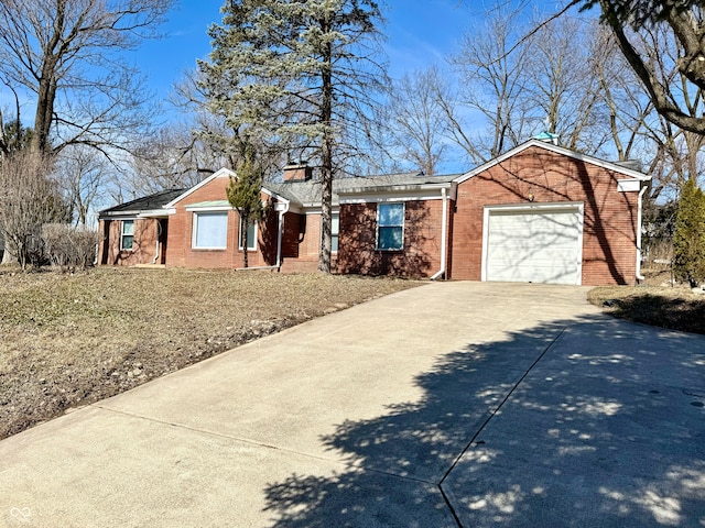 single story home with a garage, a chimney, concrete driveway, and brick siding