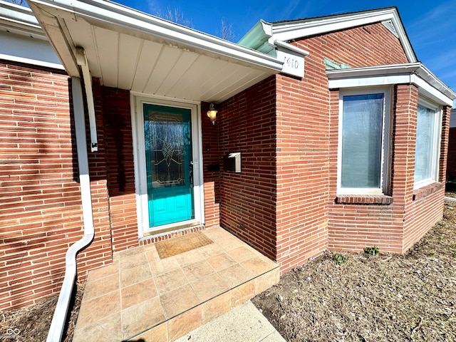 view of exterior entry with brick siding