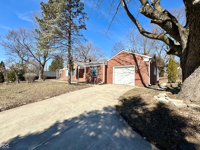 view of front of house featuring driveway, brick siding, a chimney, and an attached garage