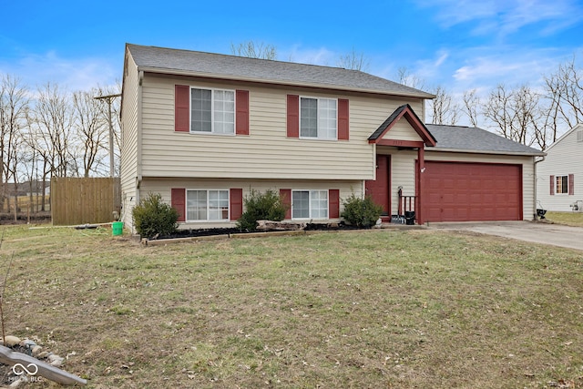 split level home featuring a garage, driveway, a front lawn, and fence