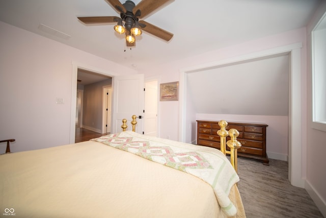 bedroom with a ceiling fan, baseboards, and wood finished floors