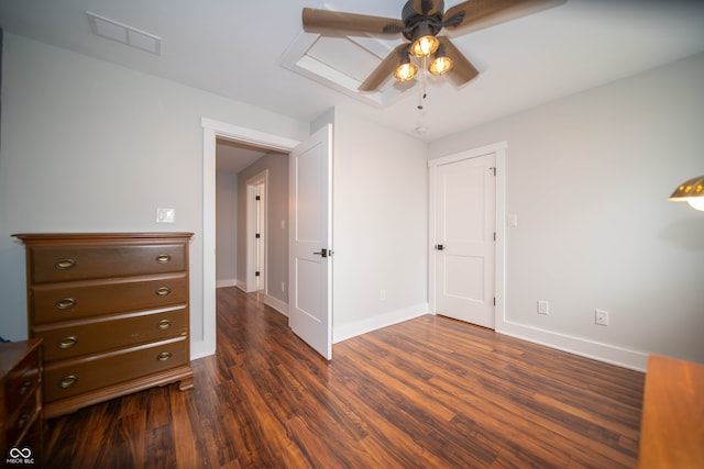 unfurnished bedroom featuring dark wood-type flooring, visible vents, ceiling fan, and baseboards