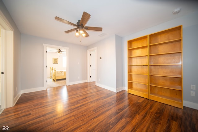 interior space featuring a ceiling fan, baseboards, and wood finished floors