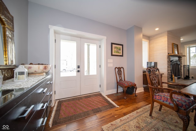 entryway with recessed lighting, a fireplace, wood finished floors, baseboards, and french doors