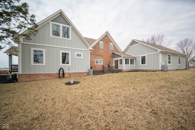 view of front of property with board and batten siding, a front yard, and cooling unit