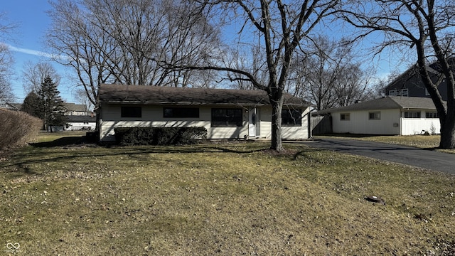 ranch-style home with aphalt driveway and a front yard