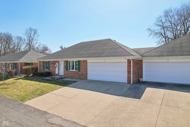 single story home with brick siding, a garage, driveway, and a front yard