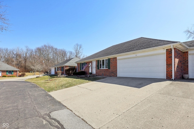 ranch-style house featuring a front yard, a garage, brick siding, and driveway