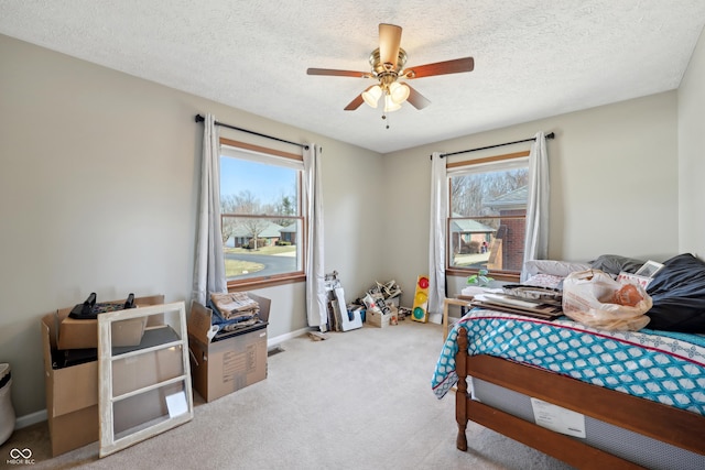 carpeted bedroom with multiple windows, a textured ceiling, and ceiling fan