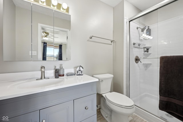 full bath with vanity, toilet, wood finished floors, and a shower stall