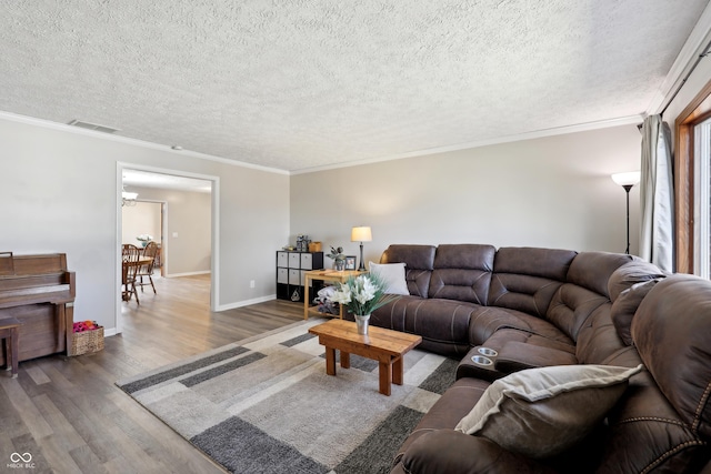 living area featuring ornamental molding, baseboards, and wood finished floors