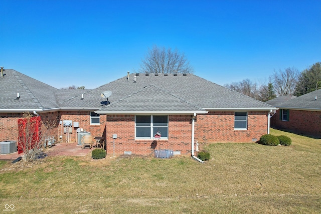 rear view of property with a lawn, roof with shingles, crawl space, brick siding, and a patio area