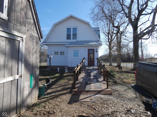 view of front of property featuring fence, metal roof, and a gambrel roof