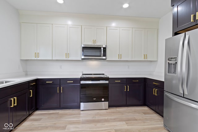 kitchen with recessed lighting, appliances with stainless steel finishes, light countertops, and white cabinetry