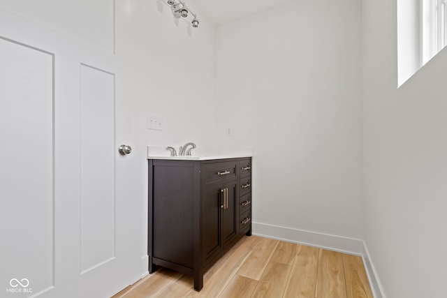 bathroom with vanity, baseboards, and wood finished floors