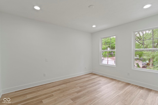 spare room with light wood-style flooring, recessed lighting, and baseboards