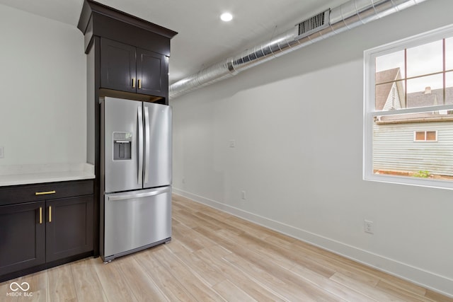 kitchen with visible vents, baseboards, light countertops, light wood-style flooring, and stainless steel refrigerator with ice dispenser