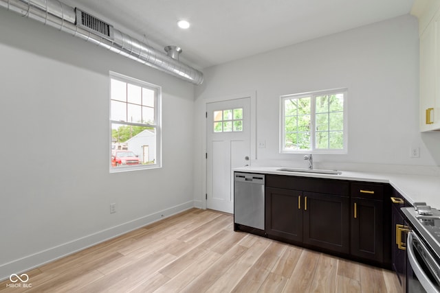 kitchen featuring light wood-type flooring, a sink, stainless steel dishwasher, baseboards, and stove