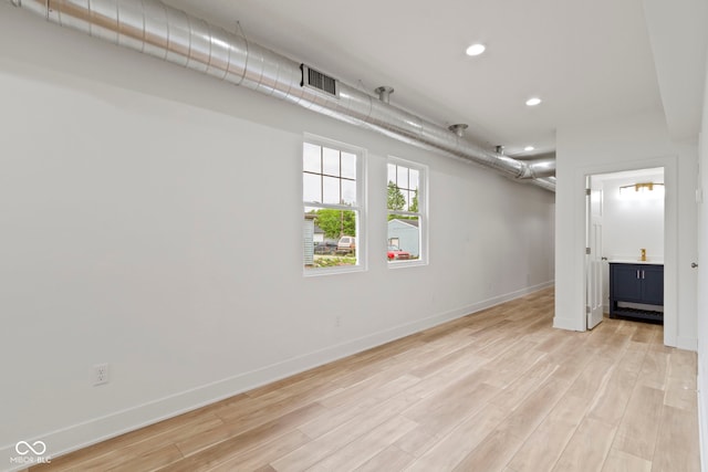 empty room with recessed lighting, visible vents, light wood-style flooring, and baseboards