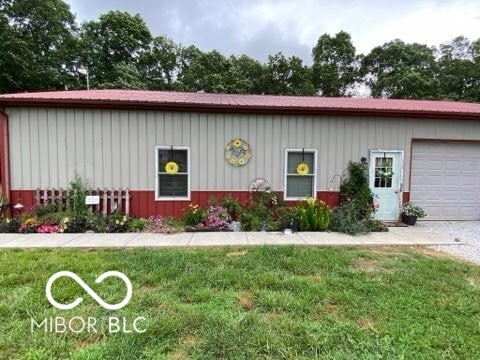 view of front of house with metal roof, a front lawn, and board and batten siding