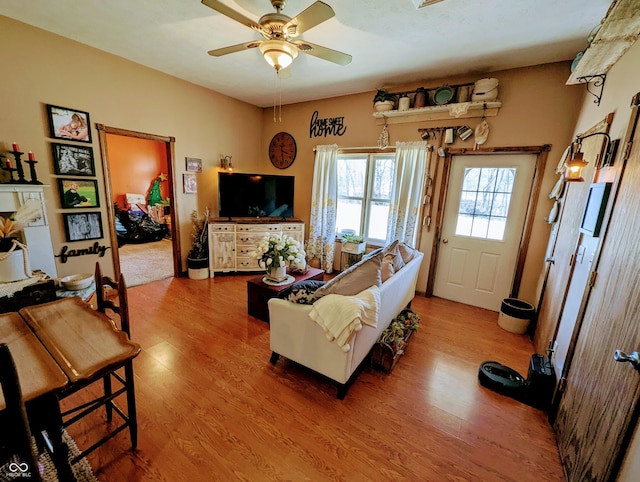 living area with wood finished floors and a ceiling fan