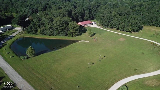 aerial view with a water view and a wooded view