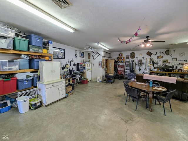 interior space featuring a ceiling fan, visible vents, and a workshop area