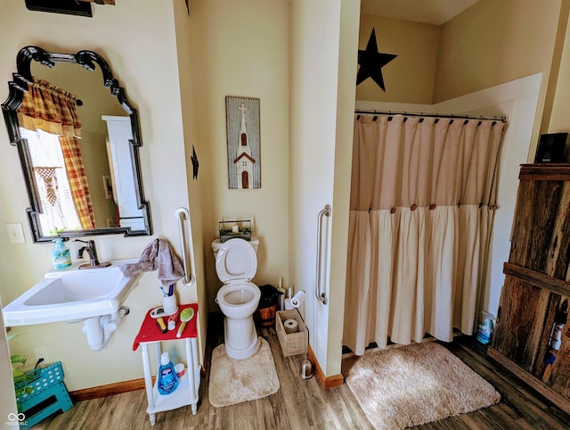 full bathroom with a shower with shower curtain, toilet, a sink, and wood finished floors