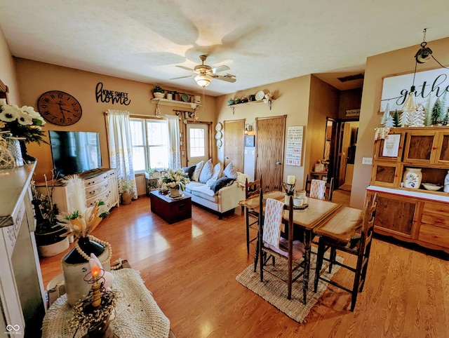 dining space with a ceiling fan, light wood-type flooring, and visible vents