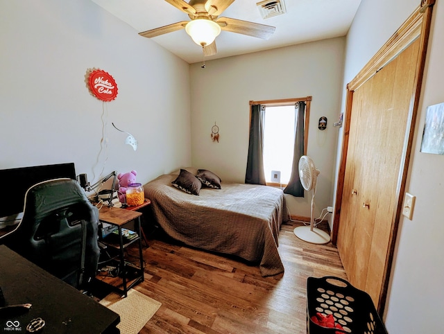 bedroom featuring wood finished floors, visible vents, and a ceiling fan