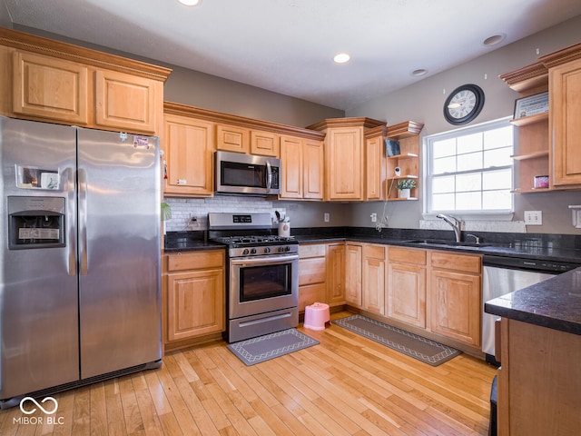 kitchen featuring a sink, light wood-style floors, appliances with stainless steel finishes, open shelves, and tasteful backsplash