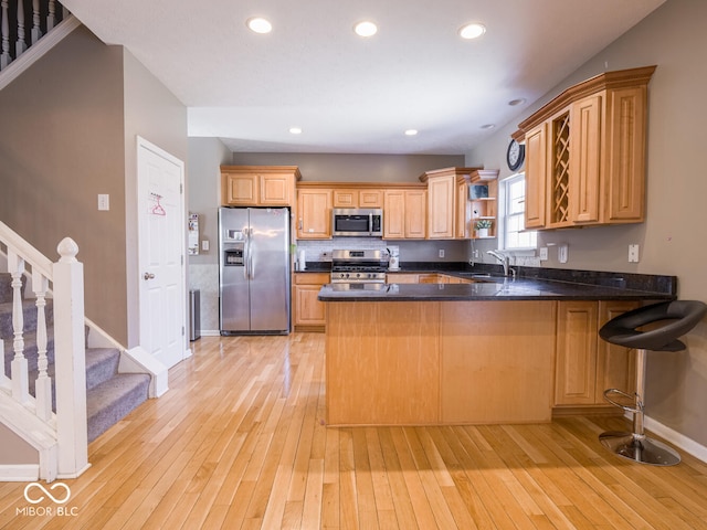 kitchen with stainless steel appliances, a peninsula, open shelves, and light wood-style floors