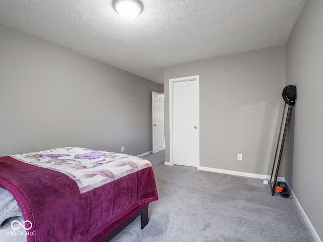 bedroom featuring a textured ceiling, baseboards, and carpet flooring