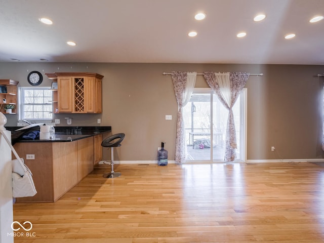 kitchen with recessed lighting, baseboards, open shelves, light wood finished floors, and dark countertops