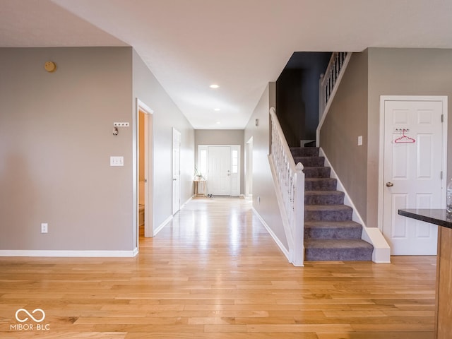 entryway with stairway, recessed lighting, light wood-style flooring, and baseboards