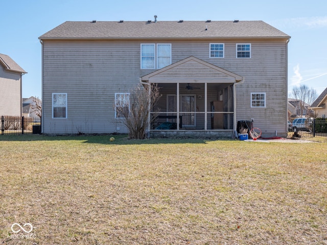 rear view of property featuring a yard, fence, and a sunroom